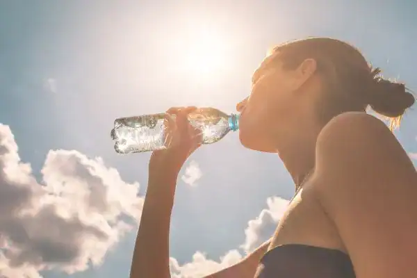 Hydration: The Secret Ingredient for a Toned Stomach and Enhanced Fitness 3 Image of woman drinking water to hydrate Cambridge after run.